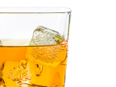 whiskey in glass with ice on white background, with space for textの写真素材
