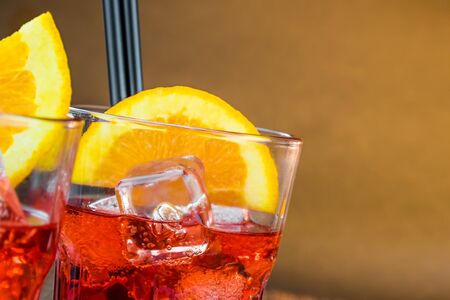 spritz aperitif aperol cocktail with orange slices and ice cubes on warm atmosphere with space for...