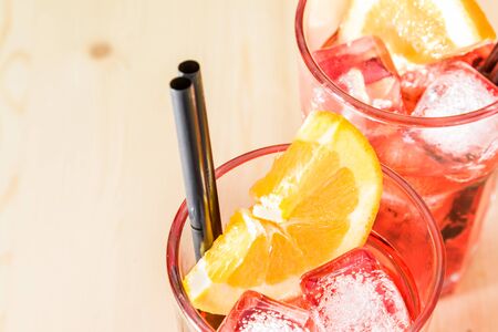 close-up of glass of spritz aperitif aperol cocktail with orange slices and ice cubes on wood table with space for textの写真素材