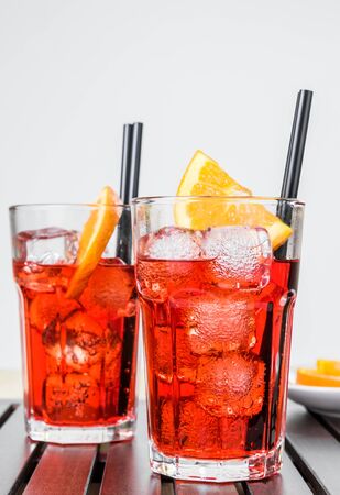 glasses of spritz aperitif aperol cocktail with orange slices and ice cubes oranges on wood tableの写真素材