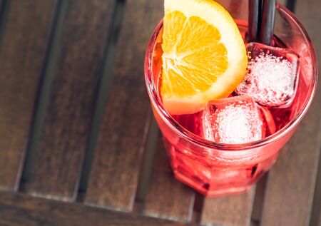 top of view of spritz aperitif aperol cocktail with orange slices and ice cubes on wood tableの写真素材