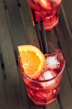 spritz aperitif aperol cocktail with orange slices and ice cubes on wood tableの写真素材