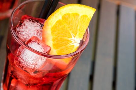 top of view of spritz aperitif aperol cocktail with orange slices and ice cubes on wood tableの写真素材