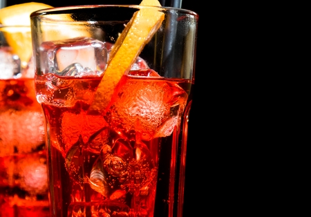 close-up of spritz aperitif aperol cocktail with orange slices and ice cubes on black backgroundの写真素材