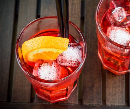 spritz aperitif aperol cocktail with orange slices and ice cubes on wood tableの写真素材