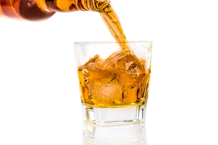 barman pouring whiskey on white background with reflection