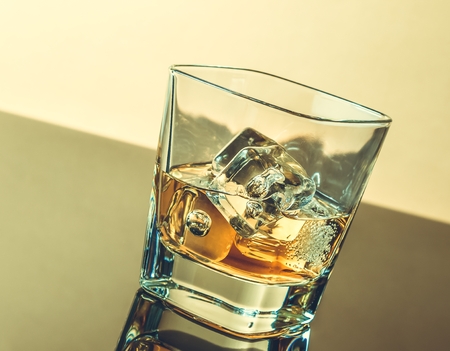 glass of whiskey on table with reflection, warm atmosphere, time of relax with whiskyの写真素材
