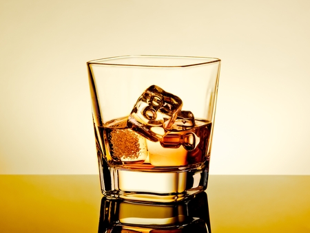 whiskey in the glass on table with reflection, warm tint atmosphere, warm tint atmosphere, time of relax with whiskyの写真素材