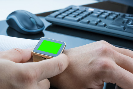 business man using smartwatch app with chroma key green screen near keyboard pc and mouse, new...