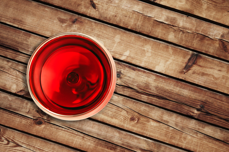top of view of red wine in the glass isolated on wood background with space for textの写真素材
