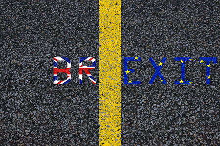 brexit blue european union EU flag and uk great britain united kingdom flag, over tarmac, road marking yellow paint separating line between words, vote for referendum united kingdom exit conceptの写真素材
