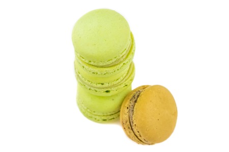 stacked green cake macaron isolated near one brown macaron on white background, maccarone sweet and colorful dessertの写真素材