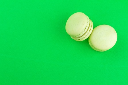 two green cake macaron on green background, maccarone sweet and colorful dessertの写真素材