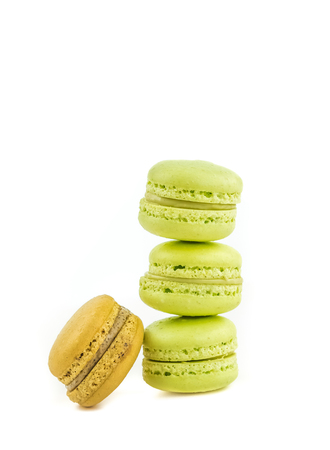 stacked green cake macaron isolated near one brown macaron on white background, maccarone sweet and colorful dessertの写真素材