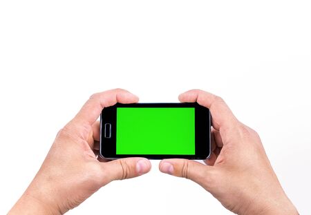 hand  of man use mobile smart phone for shot a photo with chroma key green screen on white background, new technology conceptの写真素材