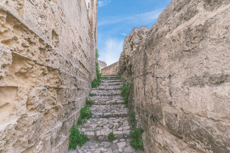 typical old stairs view of Matera under blue sky .