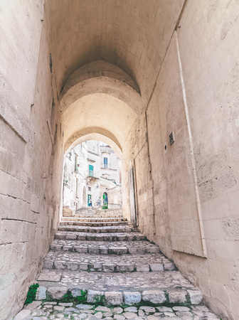 typical old stairs view of Matera under blue sky .