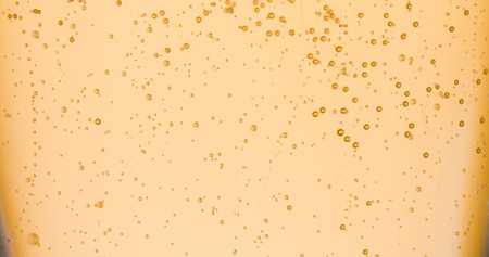 champagne golden bubbles inside a flute, gold background effect, holiday conceptの写真素材