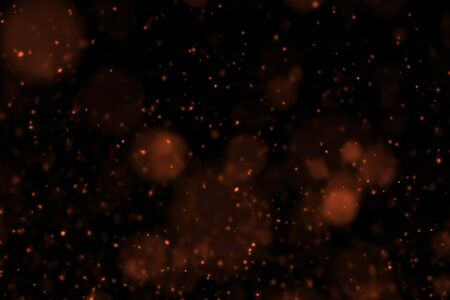 gold glow particles bokeh flowing effect on black background, holiday happy new year conceptの写真素材
