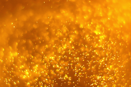 gold dust particles background with golden light spotの写真素材