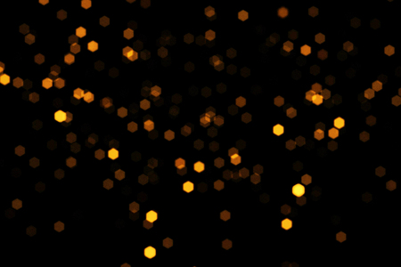 abstract gold glow particles bokeh flowing effect on black background, holiday happy new year event conceptの写真素材