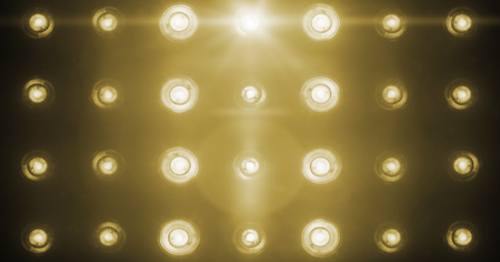 flashing shiny golden stage lights entertainment, spotlight projectors in the dark, gold warm soft light spotlight strike on black backgroundの写真素材