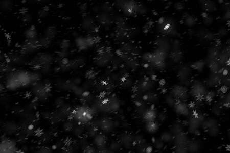 christmas snowflakes falling snow from top, winter holiday xmas event on black backgroundの写真素材
