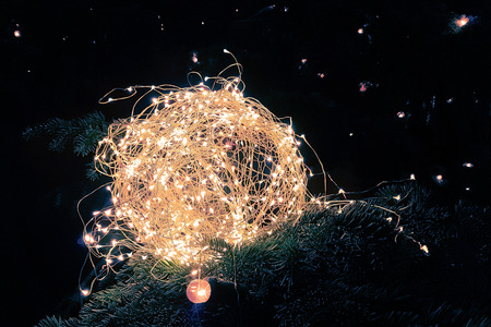 abstract Christmas glitter lights ball on xmas tree with warm sparkle bokeh on black background,...