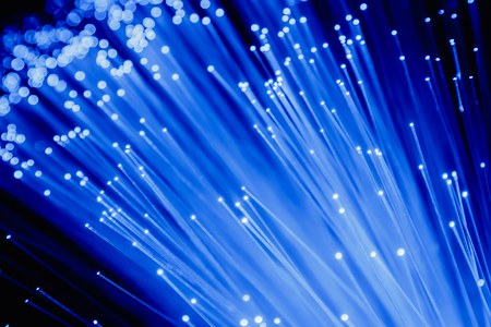 detail of blue growing bunch of optical fibers background, fast light signal for high speed internet connectionの写真素材