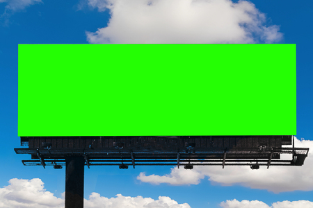 empty billboard with chroma key green screen, on blue sky with clouds, advertisement conceptの写真素材
