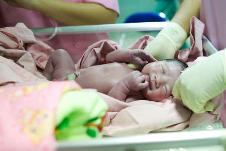 Baby just born. And nurses to remove oxygen from the lungs first
の写真素材