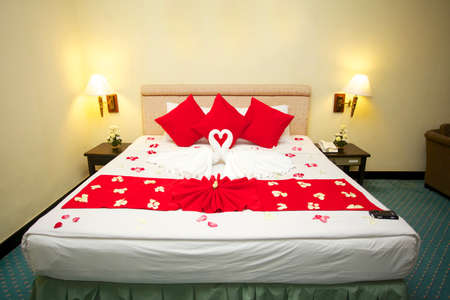Red heart pillows and two towel swans shaped on the bed,Honey moon bed

の写真素材