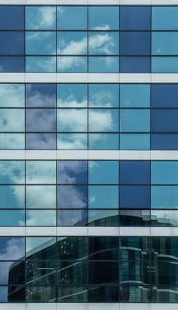 blue glass facade with sky reflection