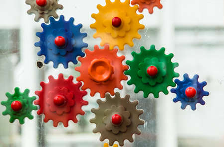 connecting colorful plastic gear wheels isolated on white background, toy that looks like engine mechanical parts for kid learning about teamworkの写真素材