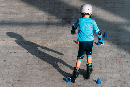 Singapore-23 MAR 2019ï¼šLittle boy riding on rollers in the summer on the ground