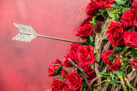 rose wreath and arrow on red backgroundの写真素材