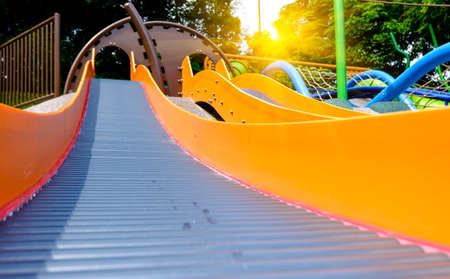 colorful long slide in public forest playground