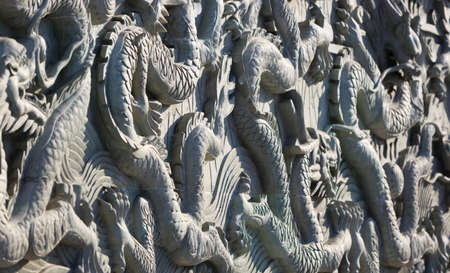 A white wall with dragon stone sculptureの写真素材