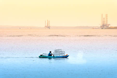Singapore-29 JUN 2019: Fisherman is fishing in the sea by placing fishing cagesのeditorial素材