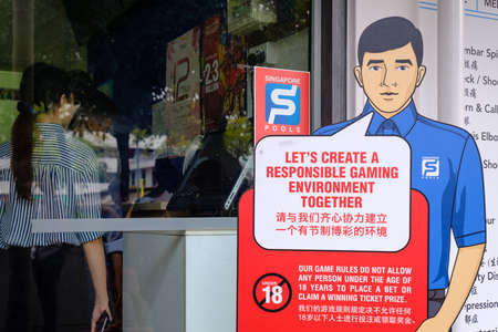 Singapore-22 FEB 2019: Customers buy lottery tickets in Singapore Pools shop