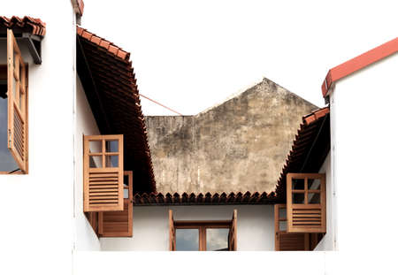 Traditional vintage shop house windows with antique shutters on a white wall