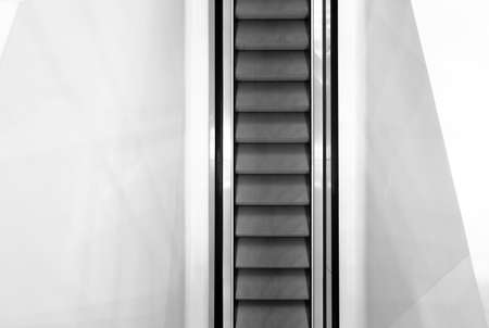 Escalator in white color wall, Moving up staircase. electric escalator