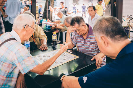 Singapore-09 JUN 2018: Chinese old man play traditional chess in the Singapore China town open plazaのeditorial素材