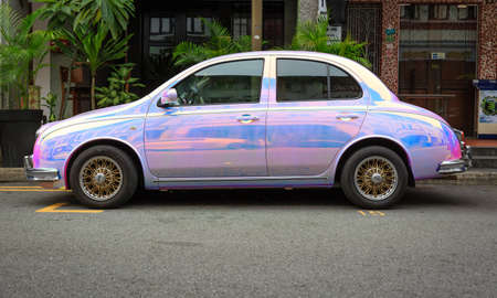 Singapore-09 JUN 2018: Shiny pink and blue vintage car parked in a traditional street