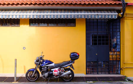 Singapore-24 MAR 2018: Motorcycle in front of a residential building in Singapore traditional areaの写真素材