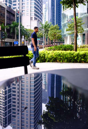 Singapore-14 APR: man walk in Singapore cbd area with water reflectionのeditorial素材