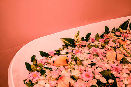 The floating flowers in white bathtub closeup