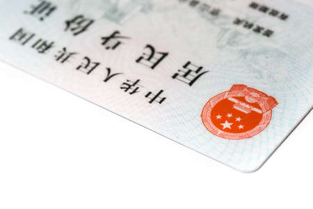 Hand holding card with national emblem of China. Translation: text on top 'People's Republic of...