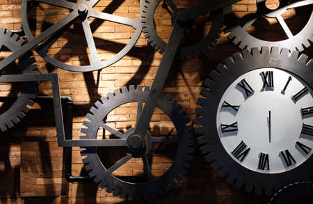 Clock on a red brick wall with cogs gearの写真素材