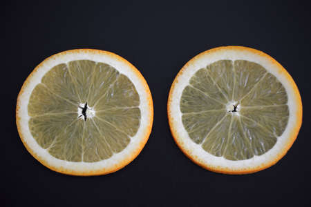 Slice of fresh orange isolated on black backgroundの写真素材